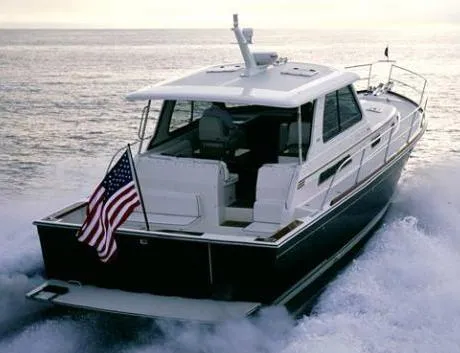 Slide: The Image of 2009 Sabre 42 Express yacht on serene water, American flag, surrounded by lush greenery. - 2