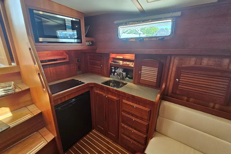 Slide: The Image of 2009 Sabre 42 Express yacht interior with wooden cabinetry and modern kitchen amenities. - 58