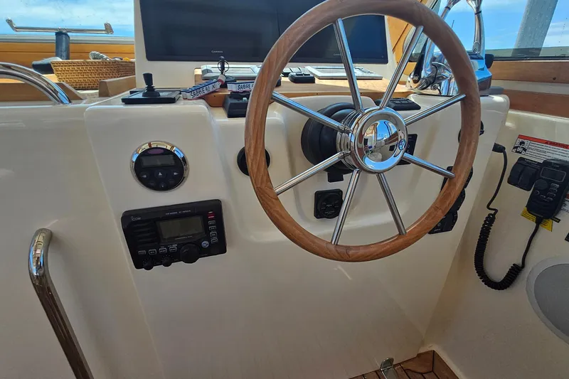 Slide: The Image of 2009 Sabre 42 Express yacht on calm water with scenic shoreline background. - 9