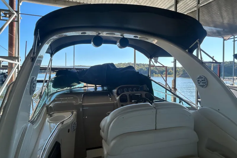 Slide: The Image of Interior of 2005 Sea Ray 300 Sundancer with seating, table, and American flag pillows. - 10