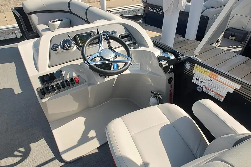 Slide: The Image of 2024 Crest Classic LX 220 boat helm with steering wheel and control panel. - 10