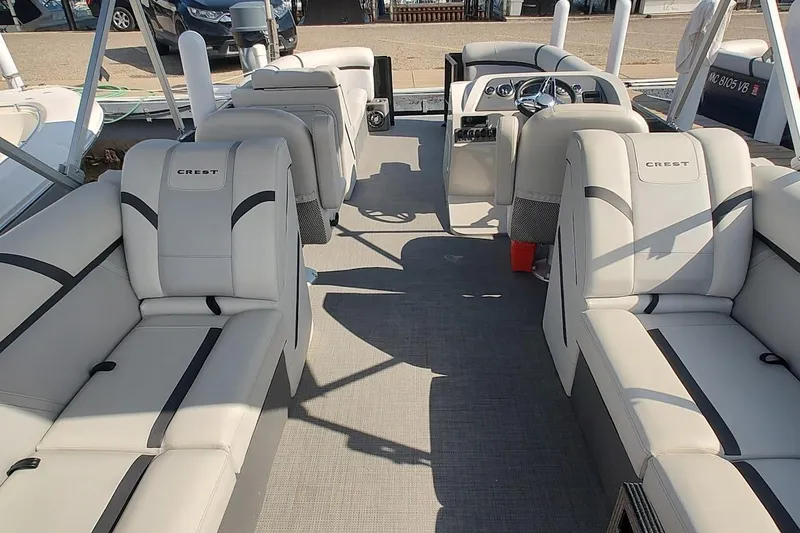 Slide: The Image of 2024 Crest Classic LX 220 pontoon boat interior with plush seating and modern design. - 11