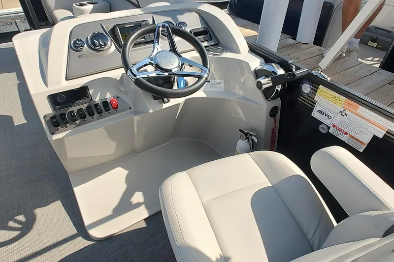 Slide: The Image of 2024 Crest Classic LX 220 boat helm with steering wheel and control panel. - 5