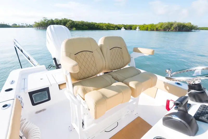 Slide: The Image of 2026 Sportsman Masters 247 Bay Boat with luxurious seating, steering wheel, and scenic water view. - 10