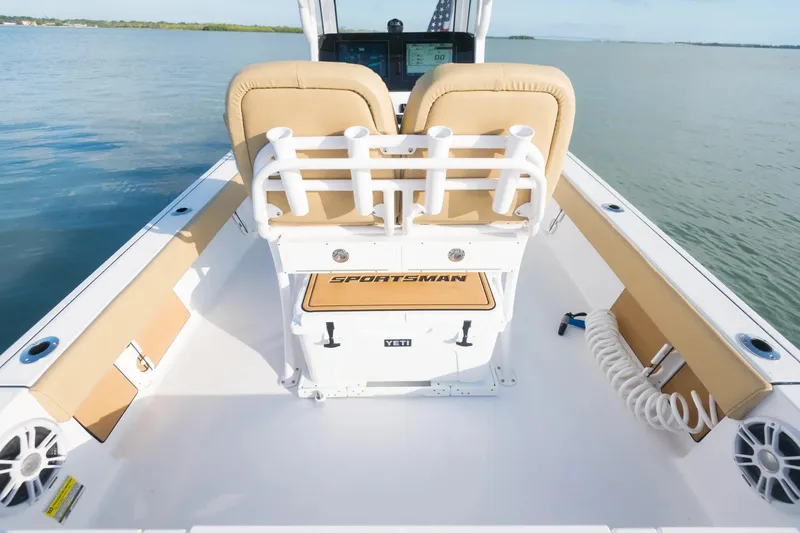 Slide: The Image of 2026 Sportsman Masters 247 Bay Boat interior with tan seating and fishing rod holders. - 11