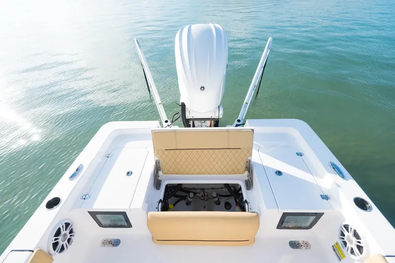 Slide: The Image of 2026 Sportsman Masters 247 Bay Boat, rear view, showcasing seating and engine on calm water. - 14