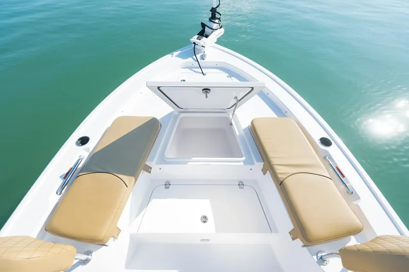 Slide: The Image of 2026 Sportsman Masters 247 Bay Boat with open storage, tan seating, and calm water backdrop. - 4