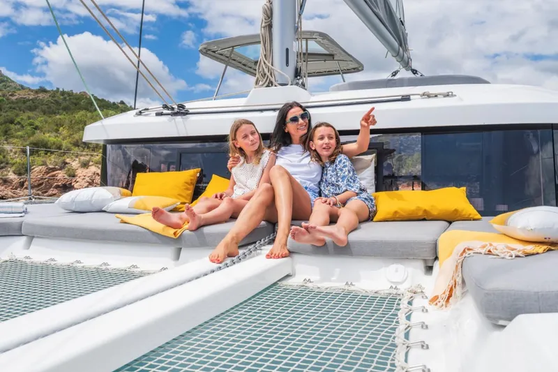 Slide: The Image of Family relaxing on a 2026 Lagoon 38 catamaran, enjoying a sunny day at sea. - 8