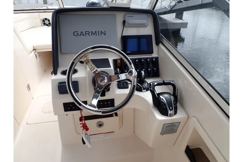 Slide: The Image of 2021 Grady-White Freedom 275 helm with Garmin navigation system and steering wheel. - 11