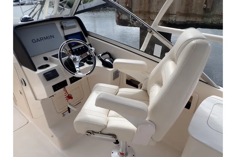 Slide: The Image of Captain's seat and helm of 2021 Grady-White Freedom 275 boat with Garmin navigation. - 13