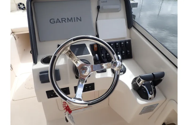 Slide: The Image of 2021 Grady-White Freedom 275 boat dashboard with Garmin navigation system and steering wheel. - 14
