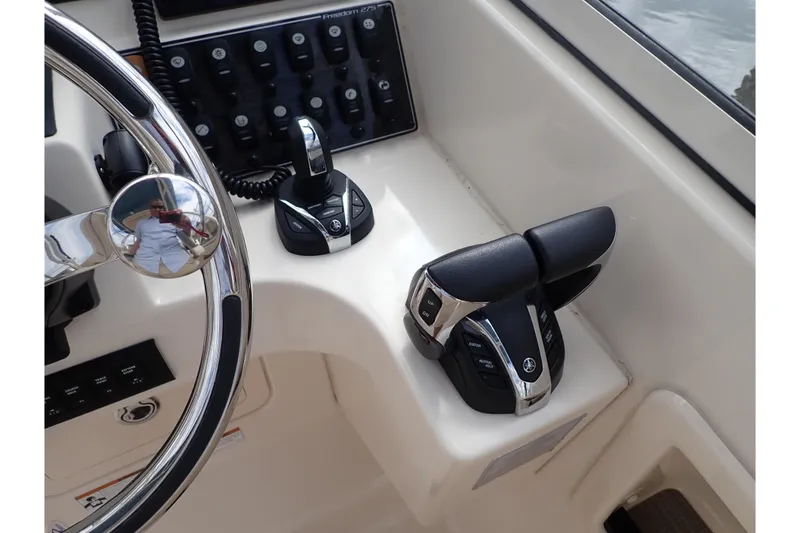 Slide: The Image of 2021 Grady-White Freedom 275 boat controls and steering wheel close-up. - 16