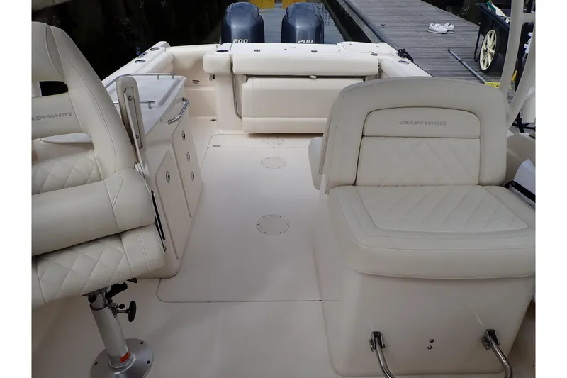 Slide: The Image of 2021 Grady-White Freedom 275 boat interior with cushioned seating and dual engines. - 23