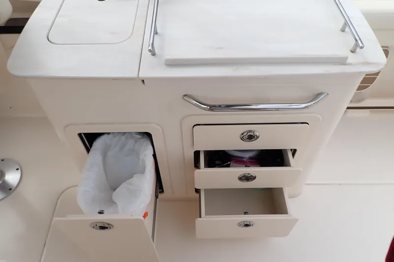 Slide: The Image of 2021 Grady-White Freedom 275 boat interior with storage drawers and trash compartment. - 27