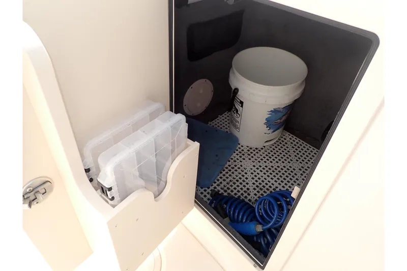 Slide: The Image of Storage compartment in 2021 Grady-White Freedom 275 boat with bucket and hose. - 37