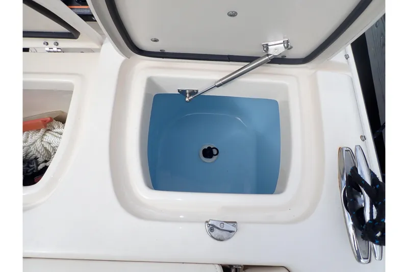 Slide: The Image of 2021 Grady-White Freedom 275 boat storage compartment with open lid and blue interior. - 38