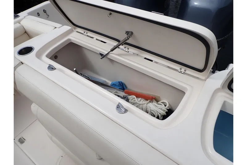 Slide: The Image of Open storage compartment on 2021 Grady-White Freedom 275 boat, containing rope and tools. - 39