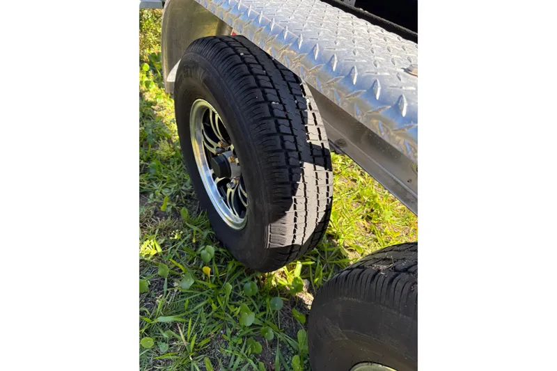 Slide: The Image of Trailer tire on grass beside Grady-White Freedom 275, 2021 model. - 54