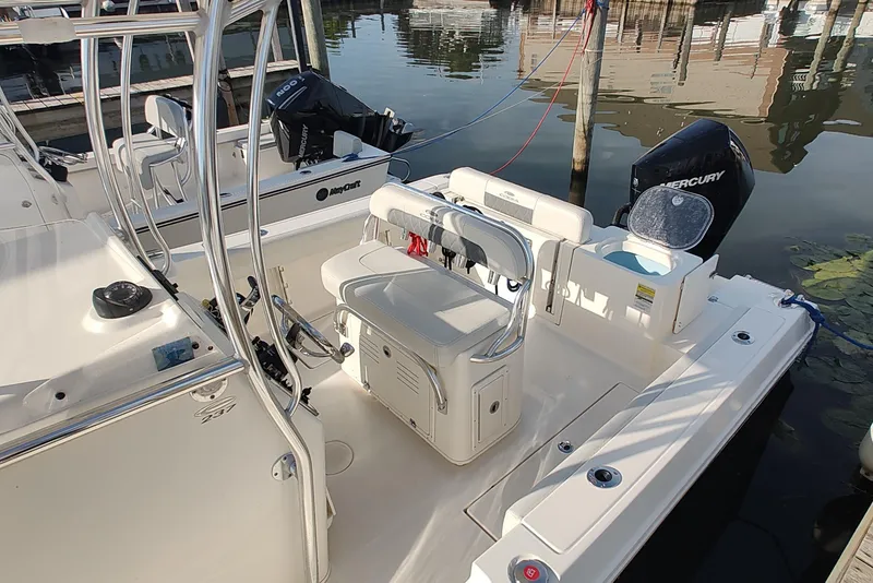 Slide: The Image of 2023 Cobia 237 Center Console boat with Mercury engine docked by the water. - 6