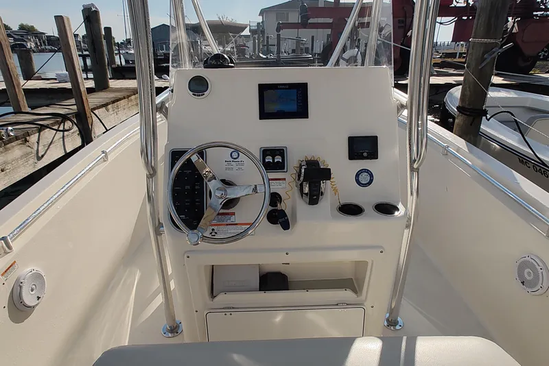 Slide: The Image of 2023 Cobia 237 Center Console boat dashboard with steering wheel and controls. - 9