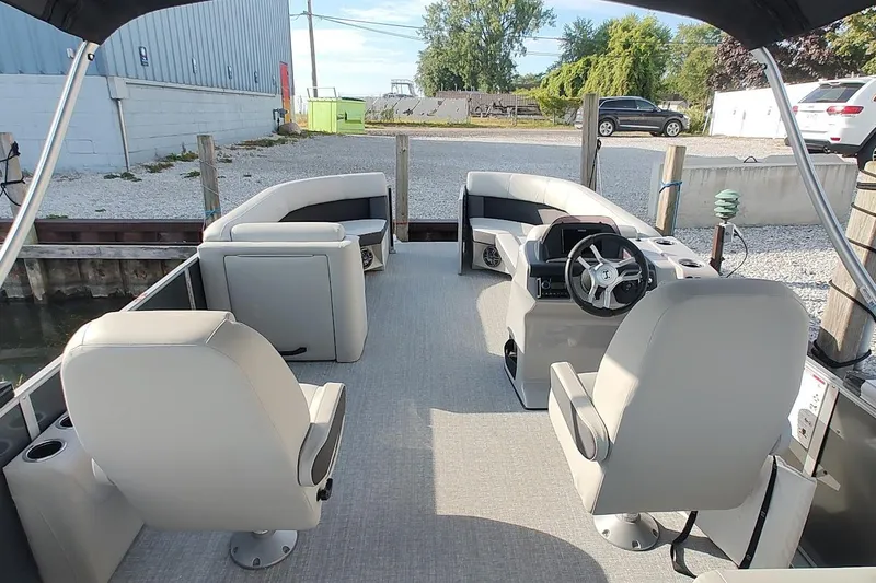 Slide: The Image of 2024 Harris Cruiser 230 pontoon boat interior with modern seating and steering wheel. - 12