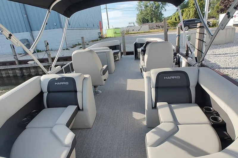 Slide: The Image of 2024 Harris Cruiser 230 pontoon boat interior with plush seating and canopy. - 13