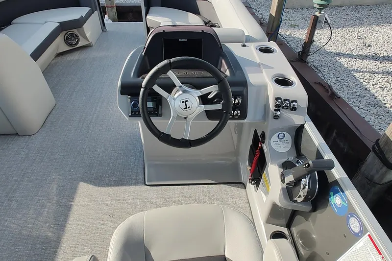 Slide: The Image of 2024 Harris Cruiser 230 boat helm with steering wheel and control panel. - 9