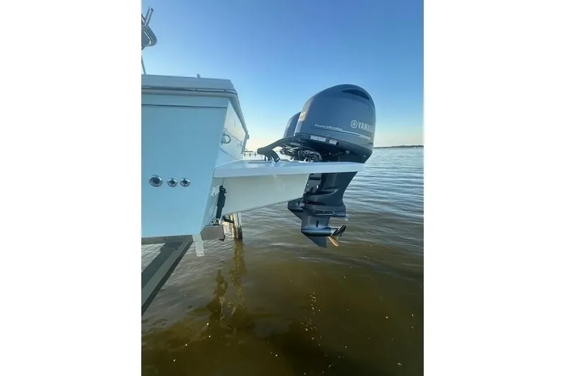 Slide: The Image of 2022 Parker 2520 XLD Sport Cabin with Yamaha outboard motor on calm water. - 2