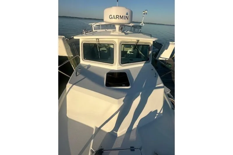 Slide: The Image of 2022 Parker 2520 XLD Sport Cabin boat with Garmin equipment on calm water. - 3