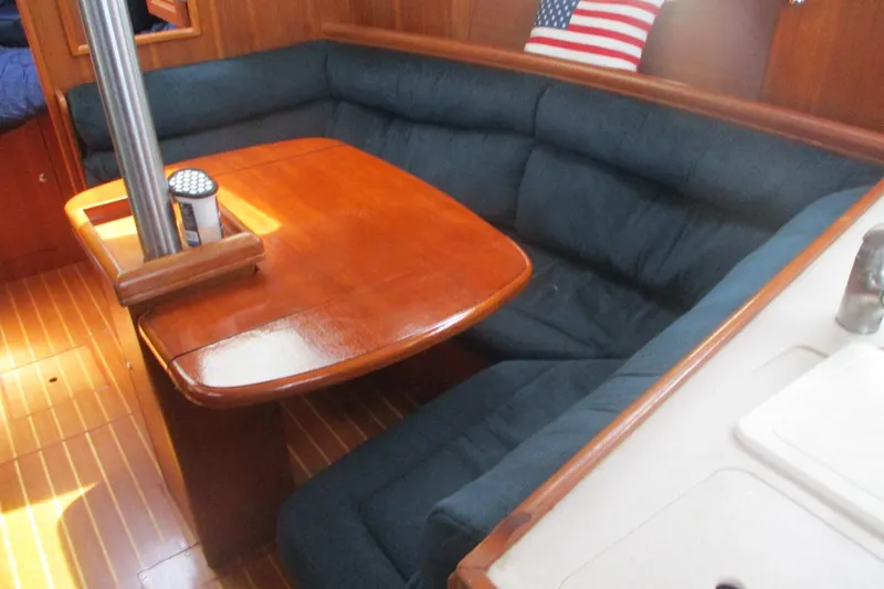 Slide: The Image of Cozy interior of 2003 Hunter 356 sailboat with wooden table and cushioned seating. - 13