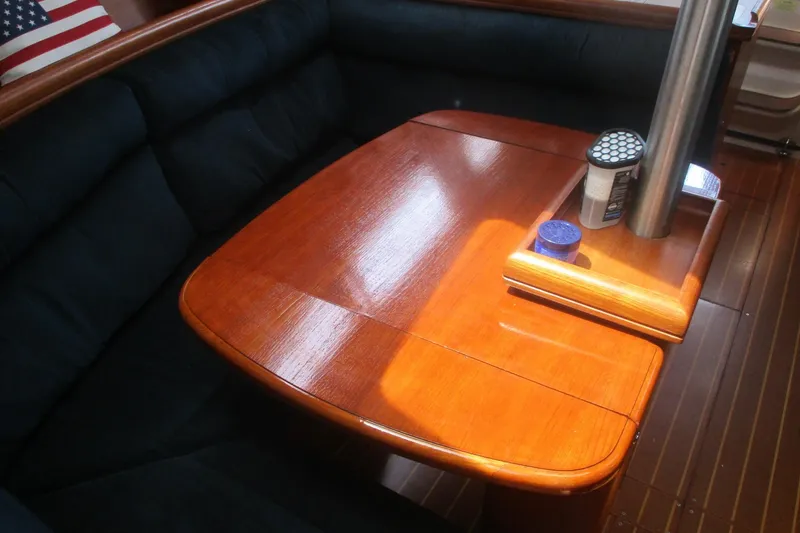 Slide: The Image of 2003 Hunter 356 yacht interior with polished wooden table and cushioned seating. - 16
