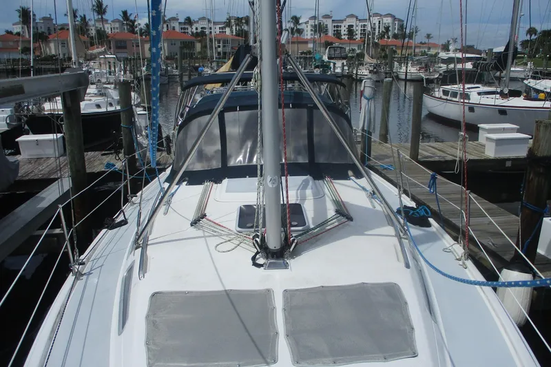 Slide: The Image of 2003 Hunter 356 sailboat docked in marina, surrounded by other boats and waterfront buildings. - 24