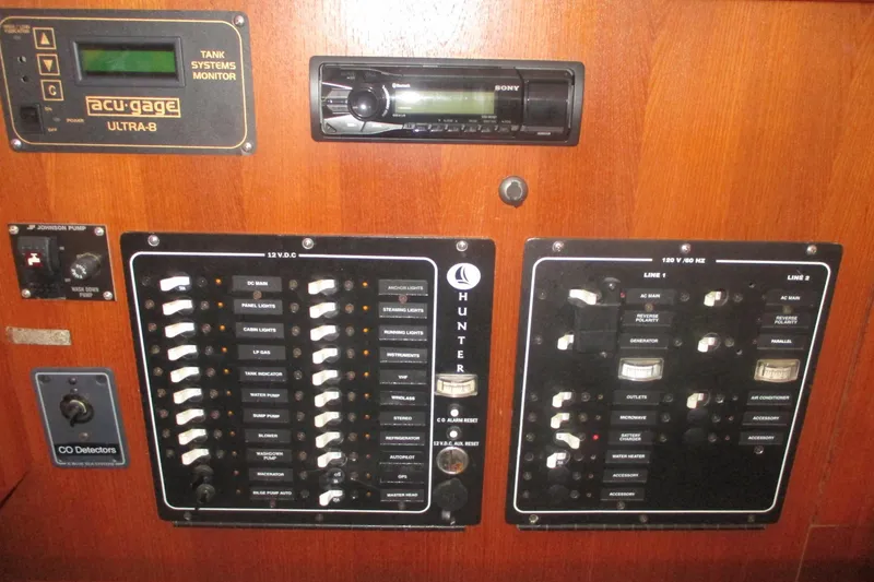 Slide: The Image of Electrical control panel of a 2003 Hunter 356 boat with various switches and monitors. - 29