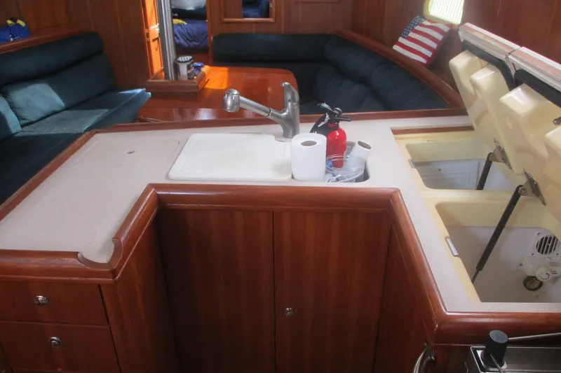 Slide: The Image of 2003 Hunter 356 yacht interior with wooden cabinetry, sink, and seating area. - 9