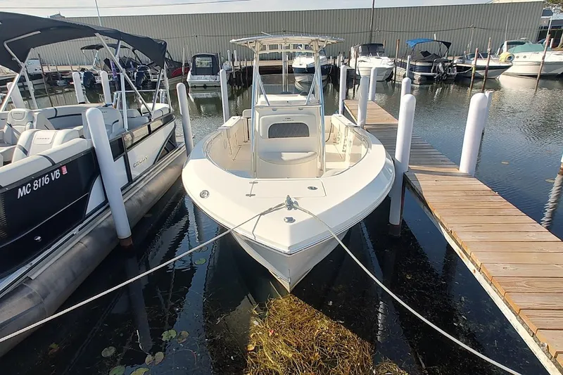 Slide: The Image of 2023 Cobia 237 Center Console boat docked at marina, surrounded by other vessels. - 3