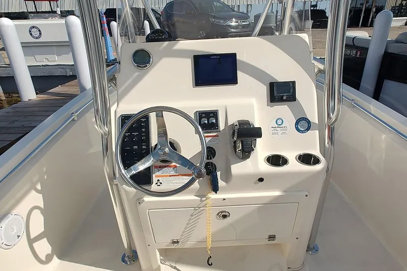 Slide: The Image of 2023 Cobia 237 Center Console boat dashboard with steering wheel and navigation controls. - 5