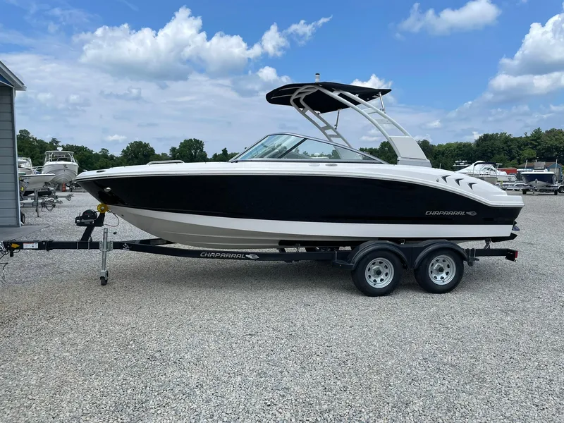 The Image of 2026 Chaparral 21 SSi boat on trailer, black and white design, parked outdoors. - 0