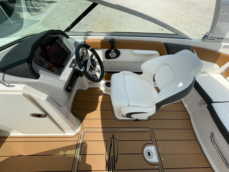 Slide: The Image of 2026 Chaparral 21 SSi boat interior with open storage compartment and modern dashboard. - 22