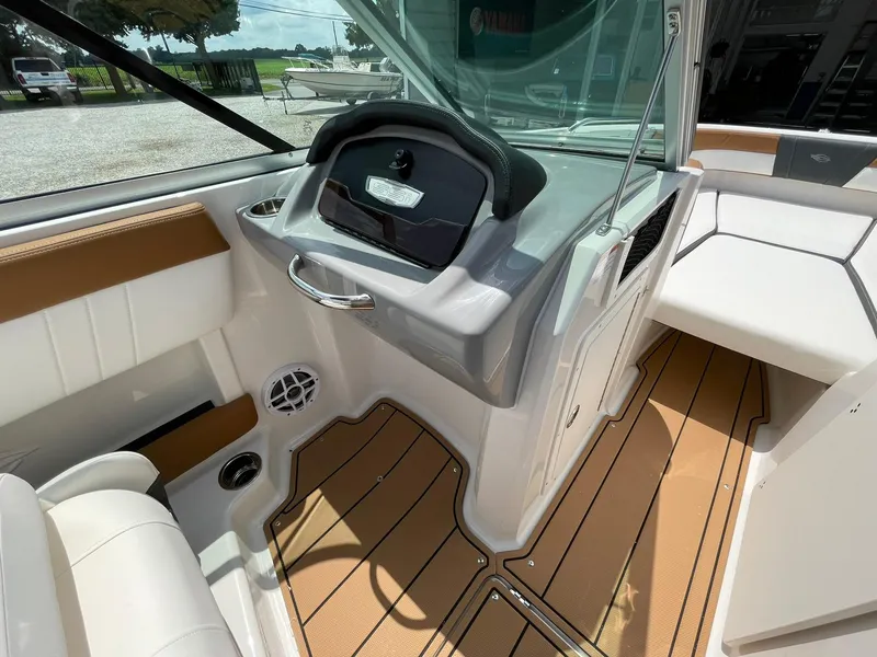 Slide: The Image of 2026 Chaparral 21 SSi boat interior with open storage compartment and modern steering wheel. - 26