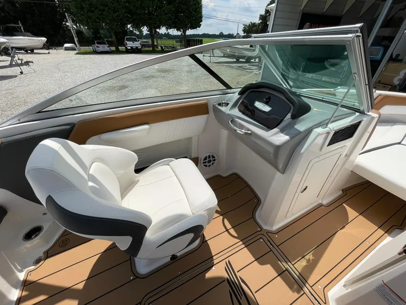 Slide: The Image of 2026 Chaparral 21 SSi boat storage compartment with open lid, showcasing interior space. - 27