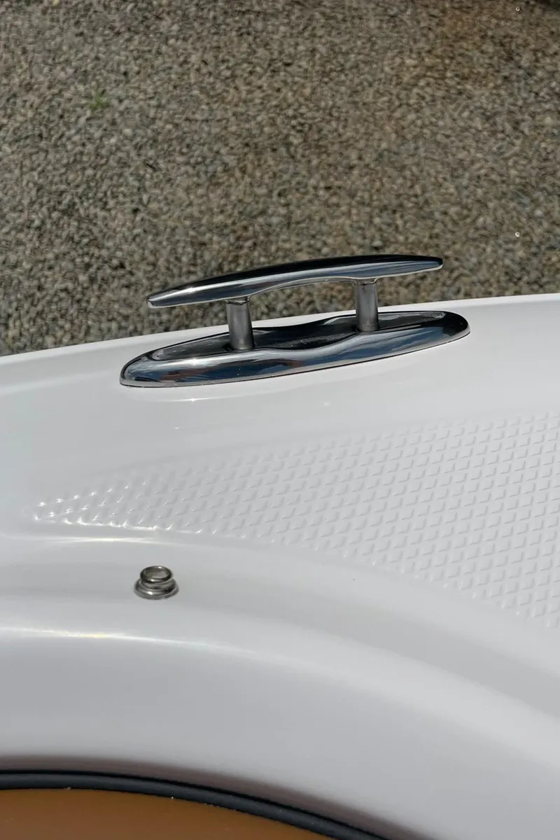 Slide: The Image of 2026 Chaparral 21 SSi boat interior with steering wheel and seating, parked among other boats. - 3