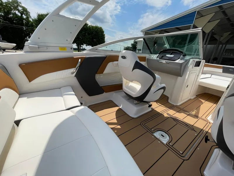 Slide: The Image of 2026 Chaparral 21 SSi boat with stylish brown and white seating under a clear blue sky. - 34