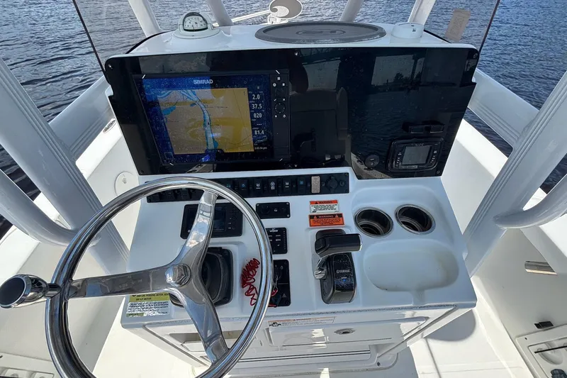 Slide: The Image of 2018 Seahunt BX25 boat console with steering wheel, navigation display, and controls. - 6