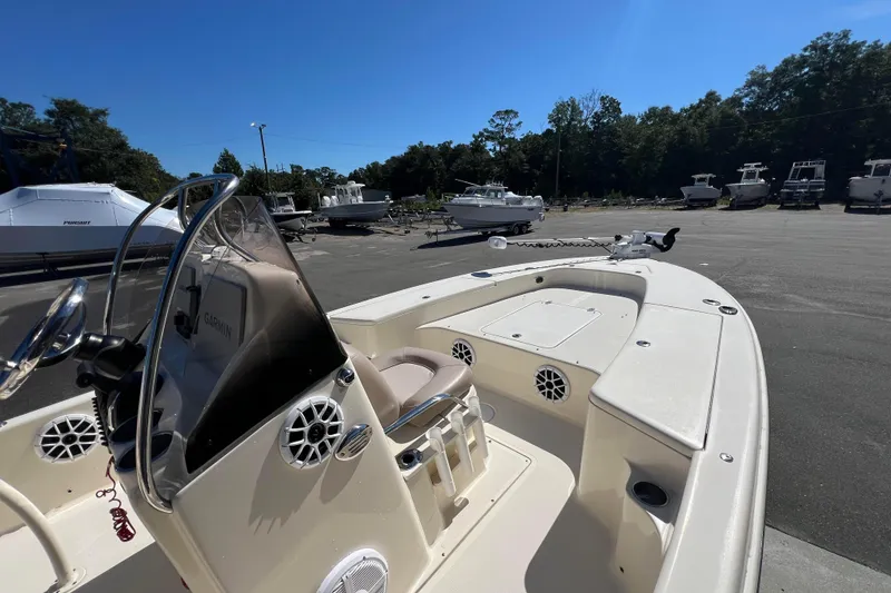 Slide: The Image of 2010 Scout 221 Winyah Bay boat in a marina, featuring console and seating area. - 10