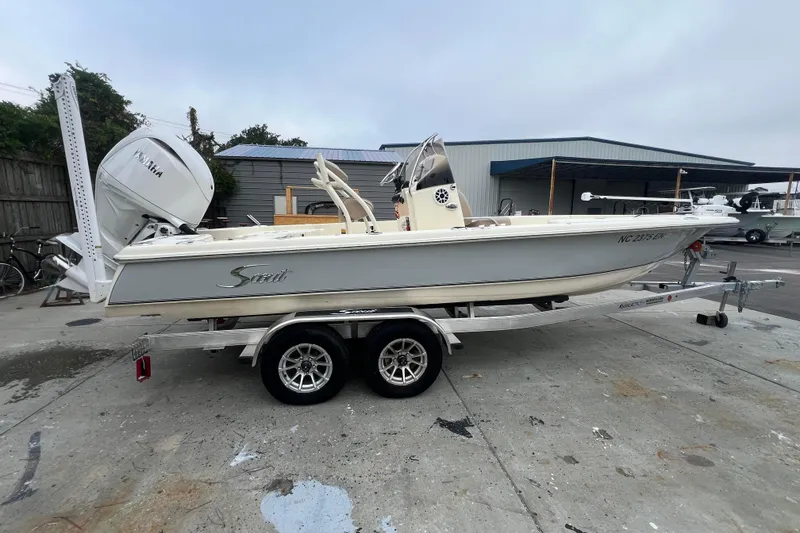 Slide: The Image of 2010 Scout 221 Winyah Bay boat on trailer with Yamaha engine, parked outdoors. - 3