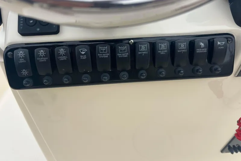 Slide: The Image of Control panel of a 2010 Scout 221 Winyah Bay boat with various switches. - 8