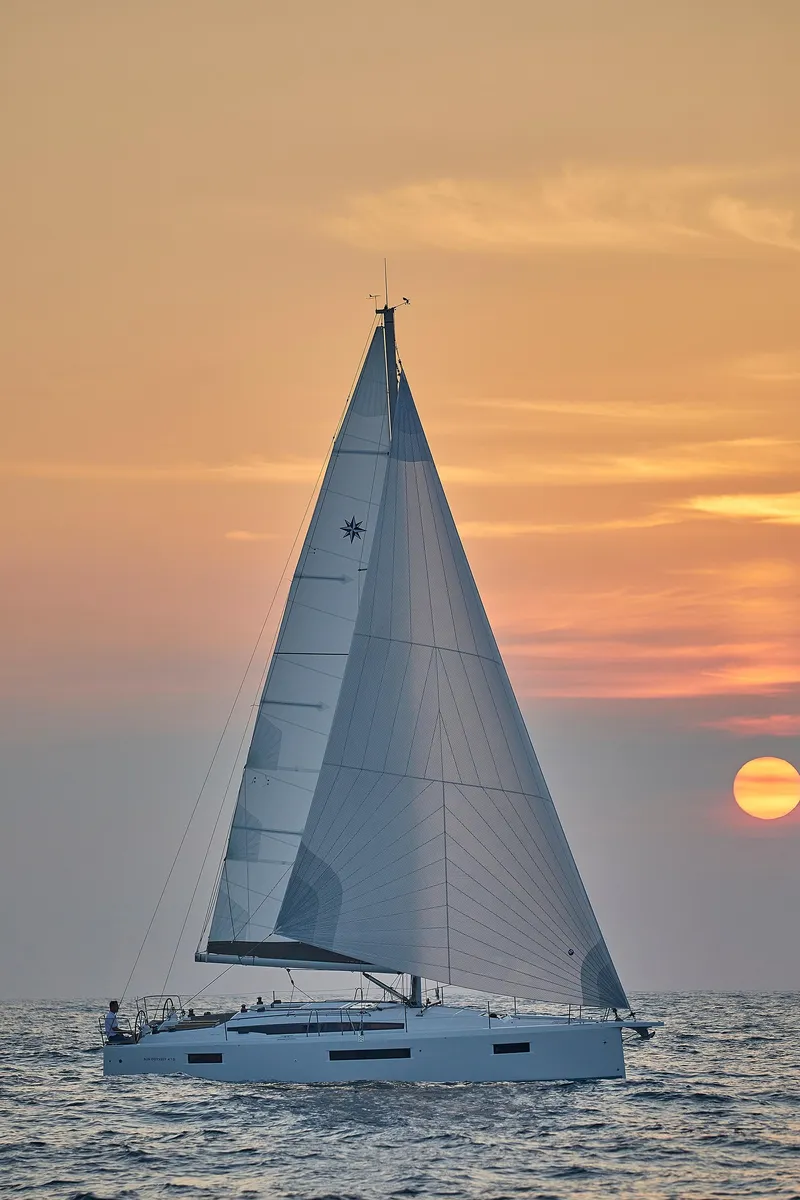 Slide: The Image of 2026 Jeanneau 410 sailboat at sunset on the ocean. - 4