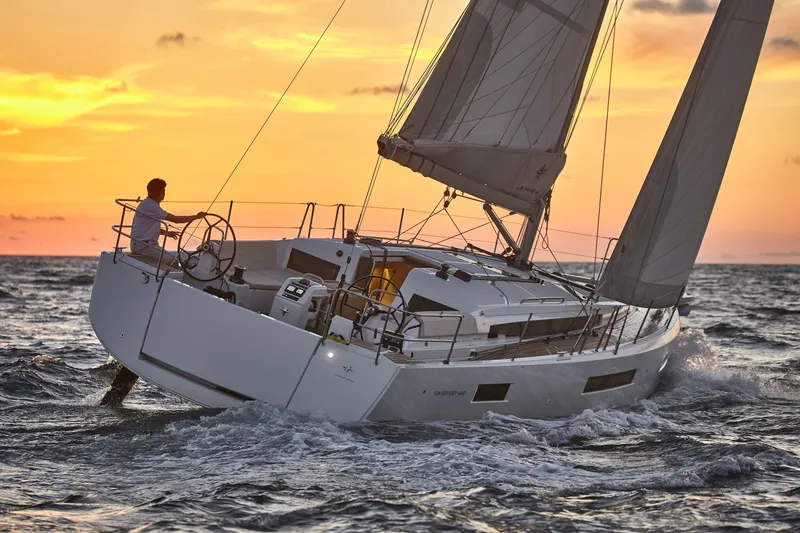 Slide: The Image of 2026 Jeanneau 440 sailboat navigating at sunset on open sea. - 1