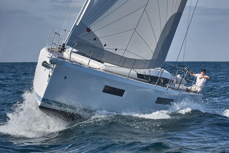 Slide: The Image of 2026 Jeanneau 440 sailboat navigating ocean waves with sails fully deployed. - 3