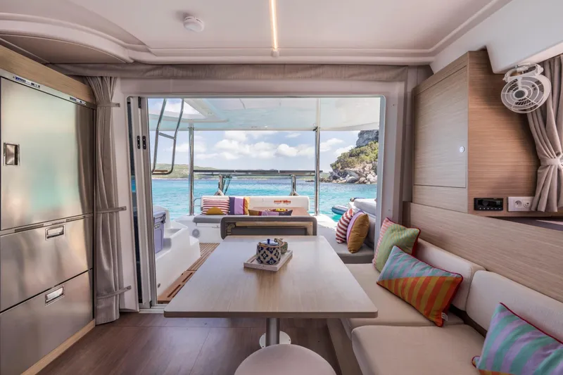 Slide: The Image of Luxurious interior of 2026 Lagoon 38 yacht with ocean view and colorful cushions. - 11